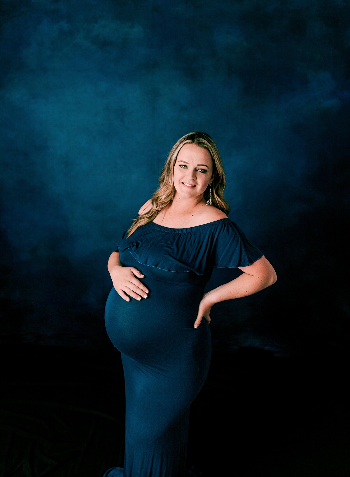 A mom expecting a baby boy wears blue at her maternity session by Diane Owen.