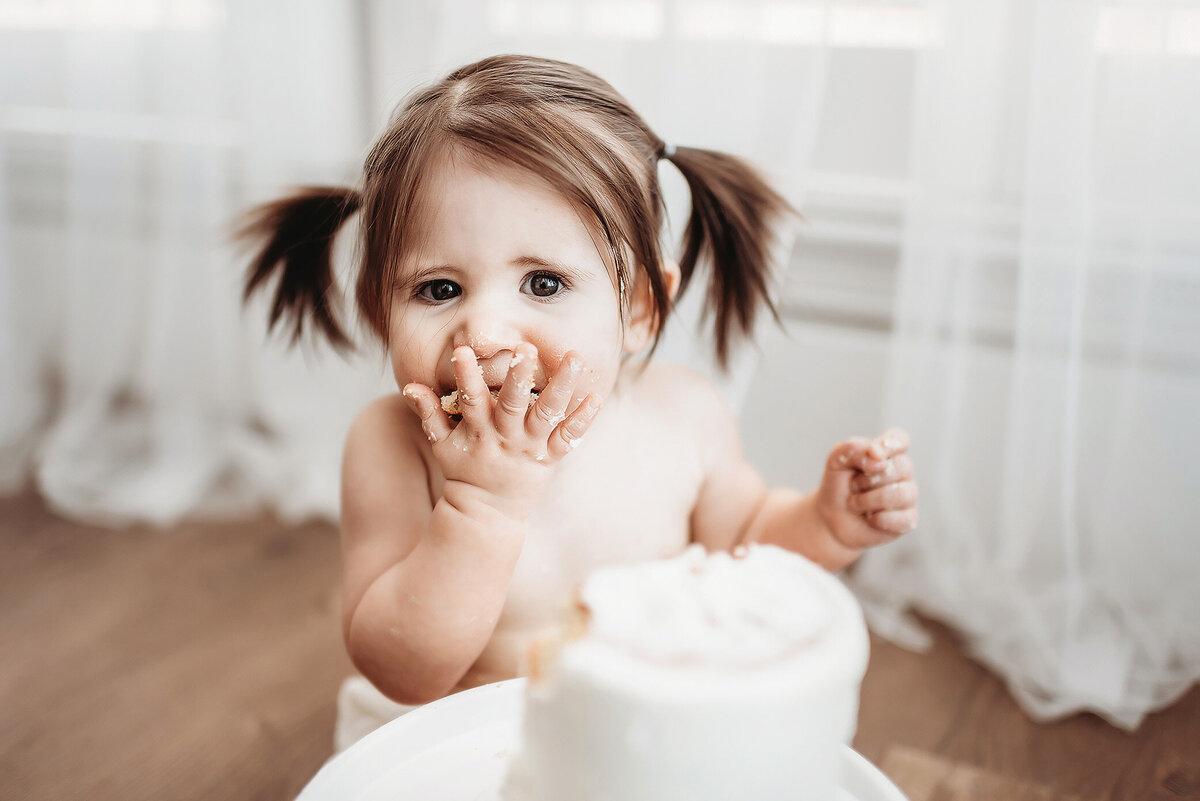 one year old milestone baby eating smash cake