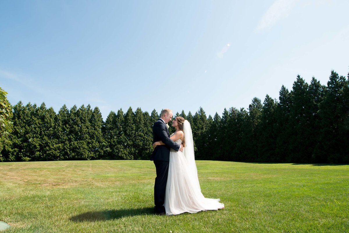 Bride and groom in each other's arms outside at Flowerfield