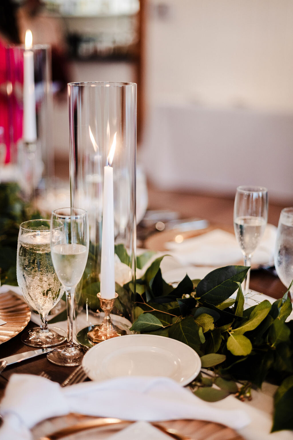 gold chargers with knot napkin, garland greenery and gold taper candles