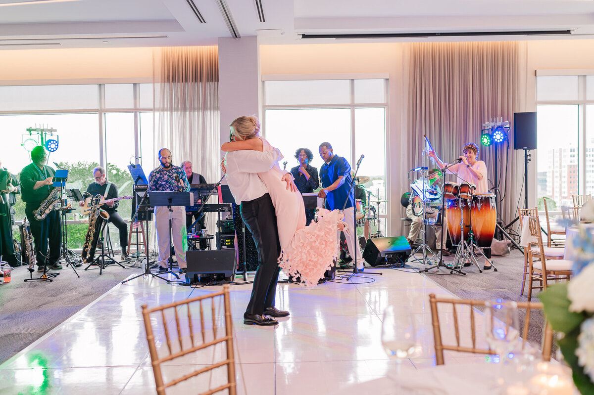 An excited newly wed couple dancing on the dance floor at their reception in downtown Raleigh enjoying their Raleigh wedding photography session with JoLynn Photography
