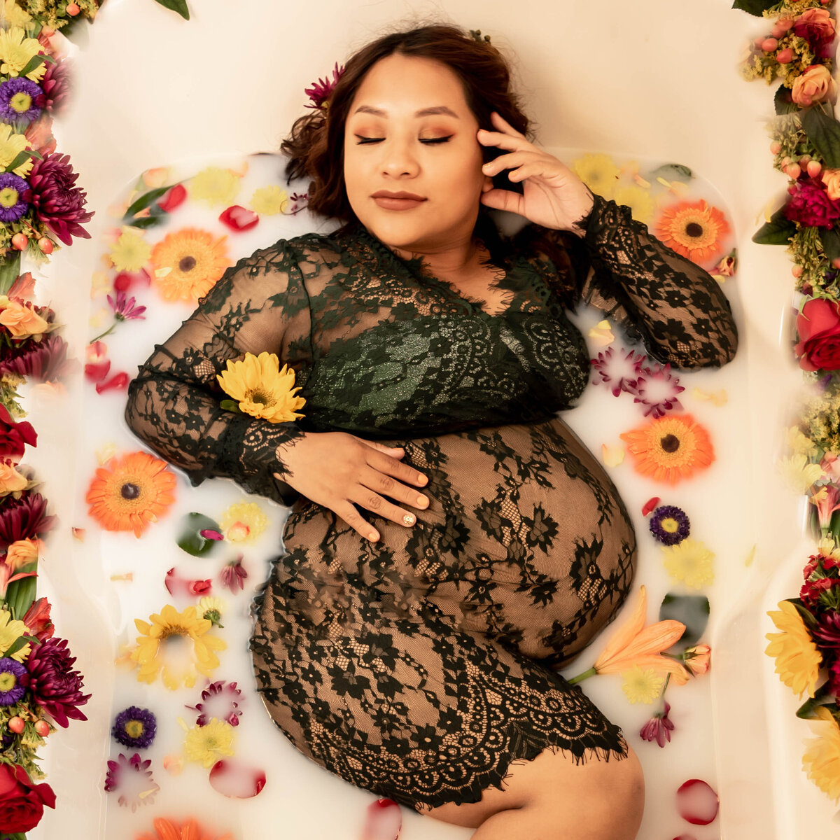 Mother to be takes a moment to relax in a floral milk bath