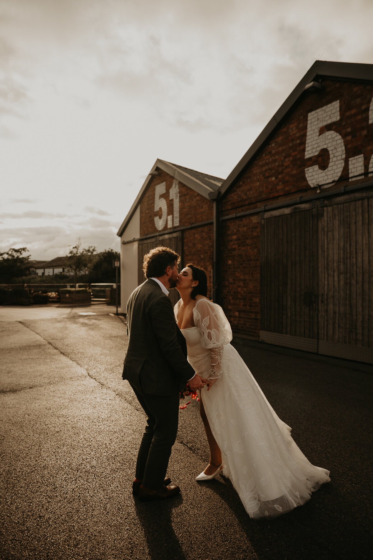 A Bride and Groom kiss during sunset at their wedding at Paintworks in Bristol. 