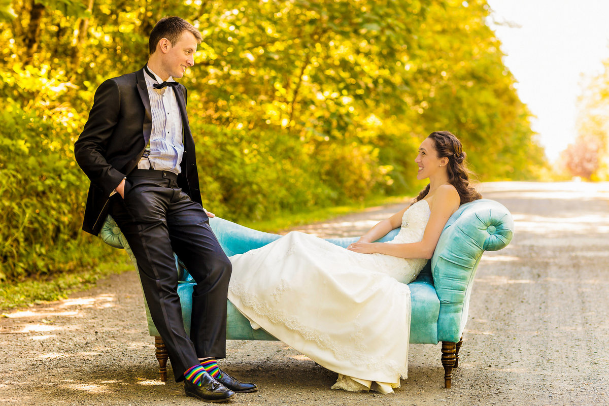 Outdoor wedding bride and groom sitting on a sofa on a dirt road