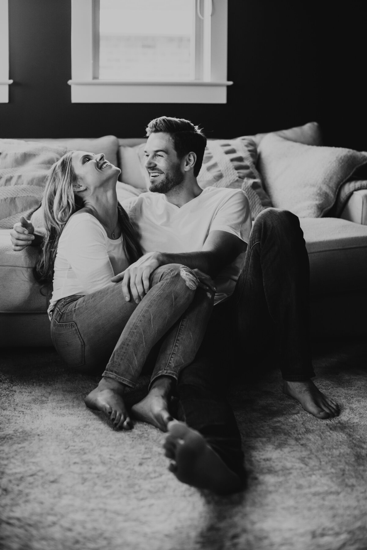 couple sitting on the floor smiling at each other in home