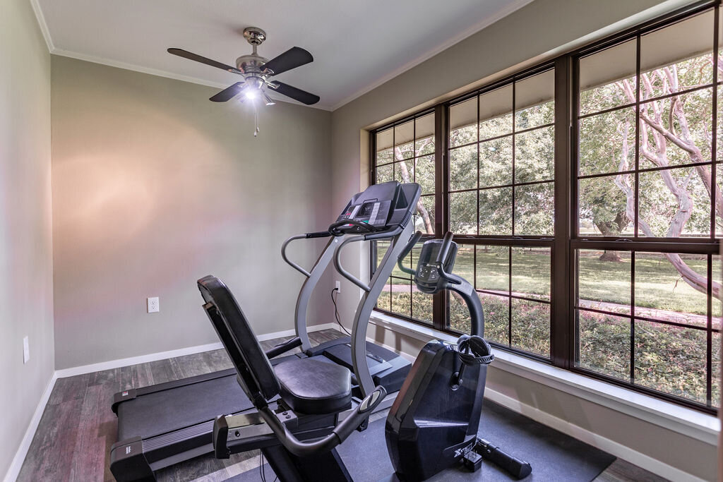 Exercise room with treadmill and stationary bike in this 5-bedroom, 4-bathroom vacation rental house for 16+ guests with pool, free wifi, guesthouse and game room just 20 minutes away from downtown Waco, TX.