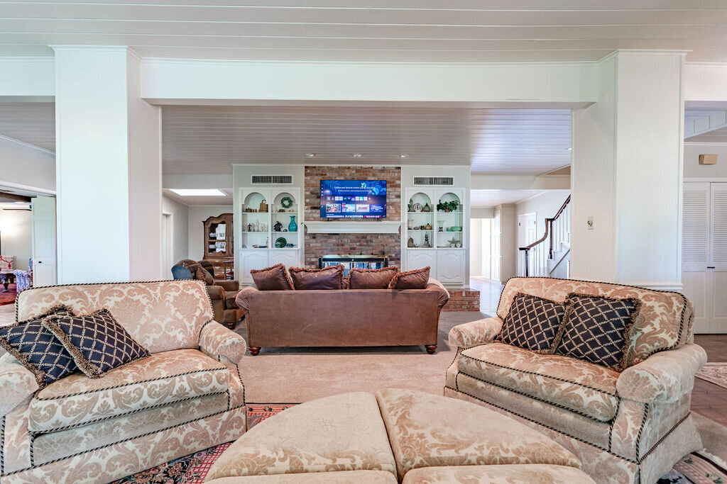 Beautiful living room with plenty of comfortable seating and smart TV in this 5-bedroom, 4-bathroom vacation rental house for 16+ guests with pool, free wifi, guesthouse and game room just 20 minutes away from downtown Waco, TX.