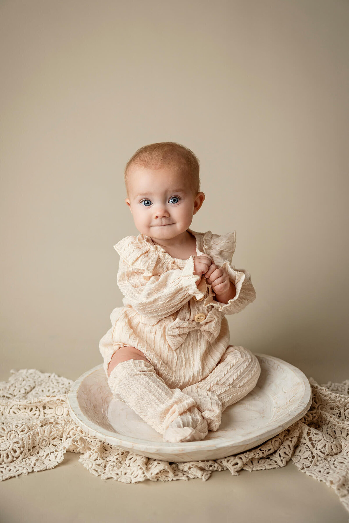 Baby girl posed in off white outfit for her milesone session at Jennifer Brandes Photography.
