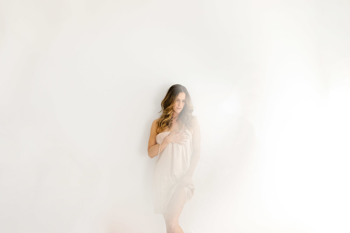 Lady in a white studio during bridal boudoir session