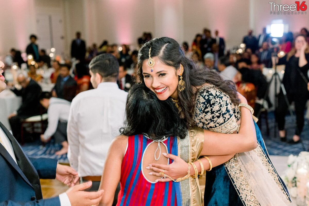 Bride hugs a family member at her wedding reception