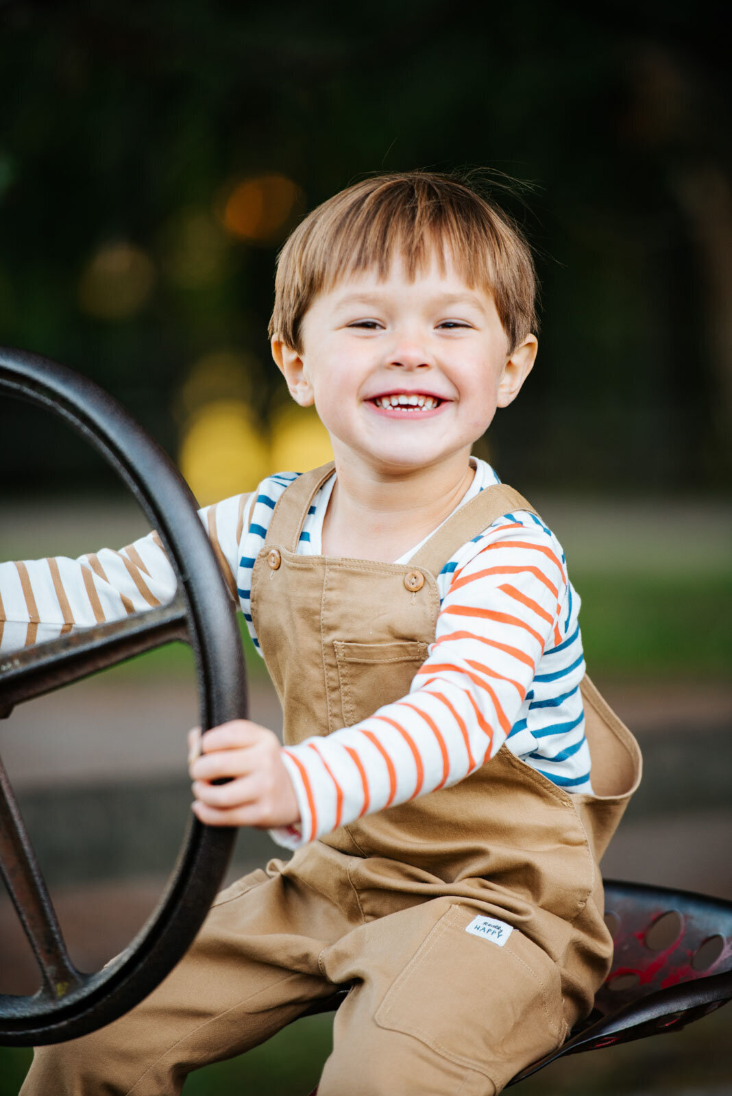 toddler boy vermont on tractor in overalls