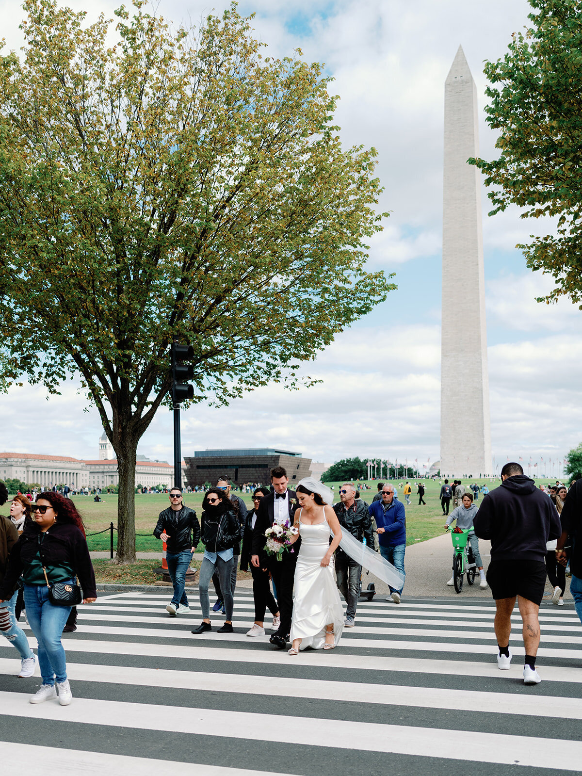 Bride and groom cross the sidewalk as they are headed to the Lincoln memorial in DC