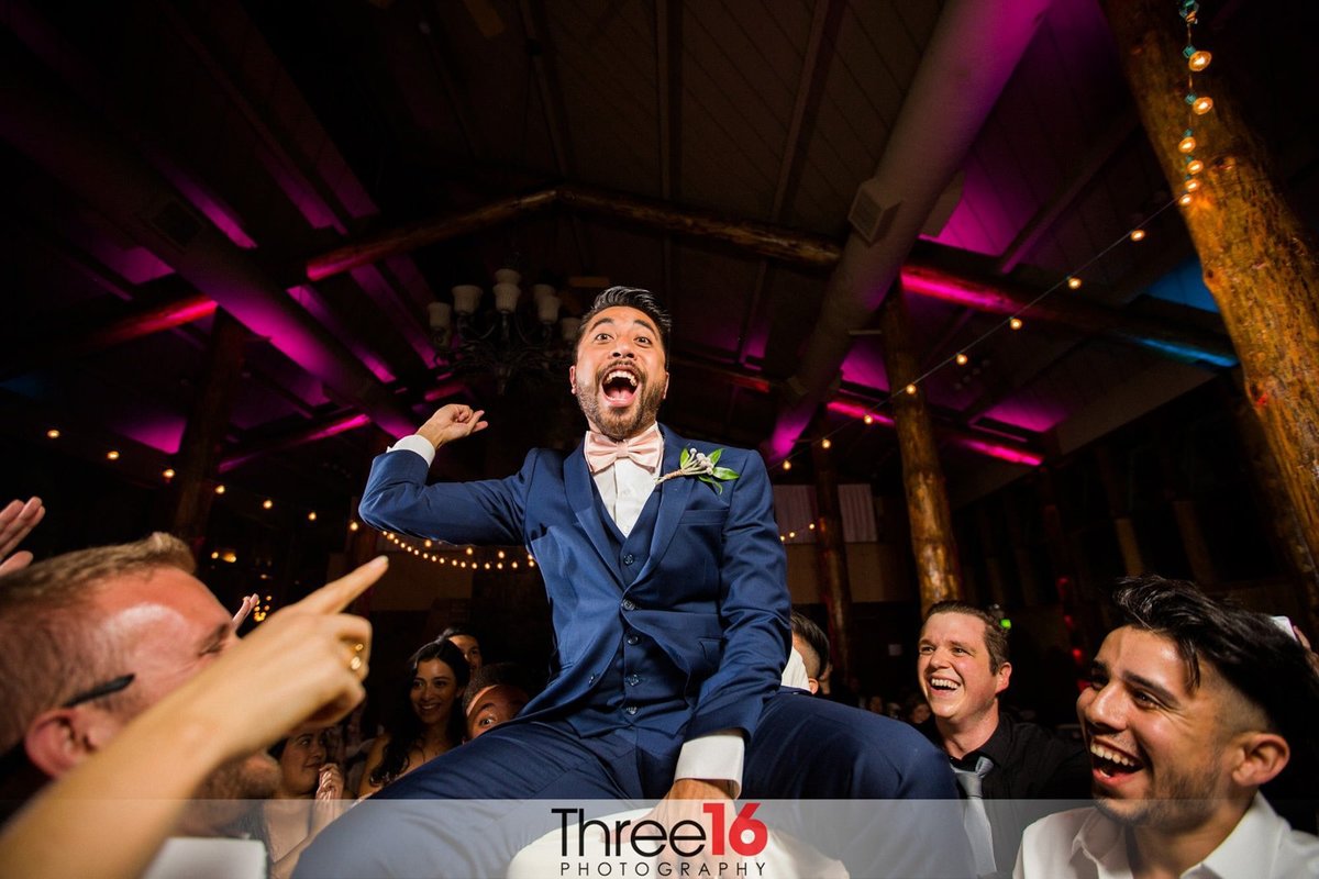 Groom lifted in the air as he dances at his reception