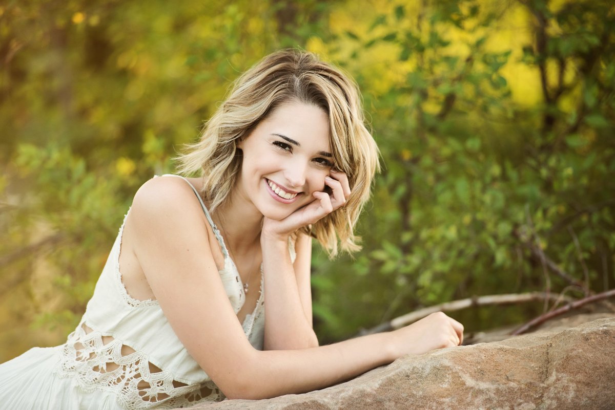Elk River Minnesota high school senior picture of girl  leaning on rock by a river in nature
