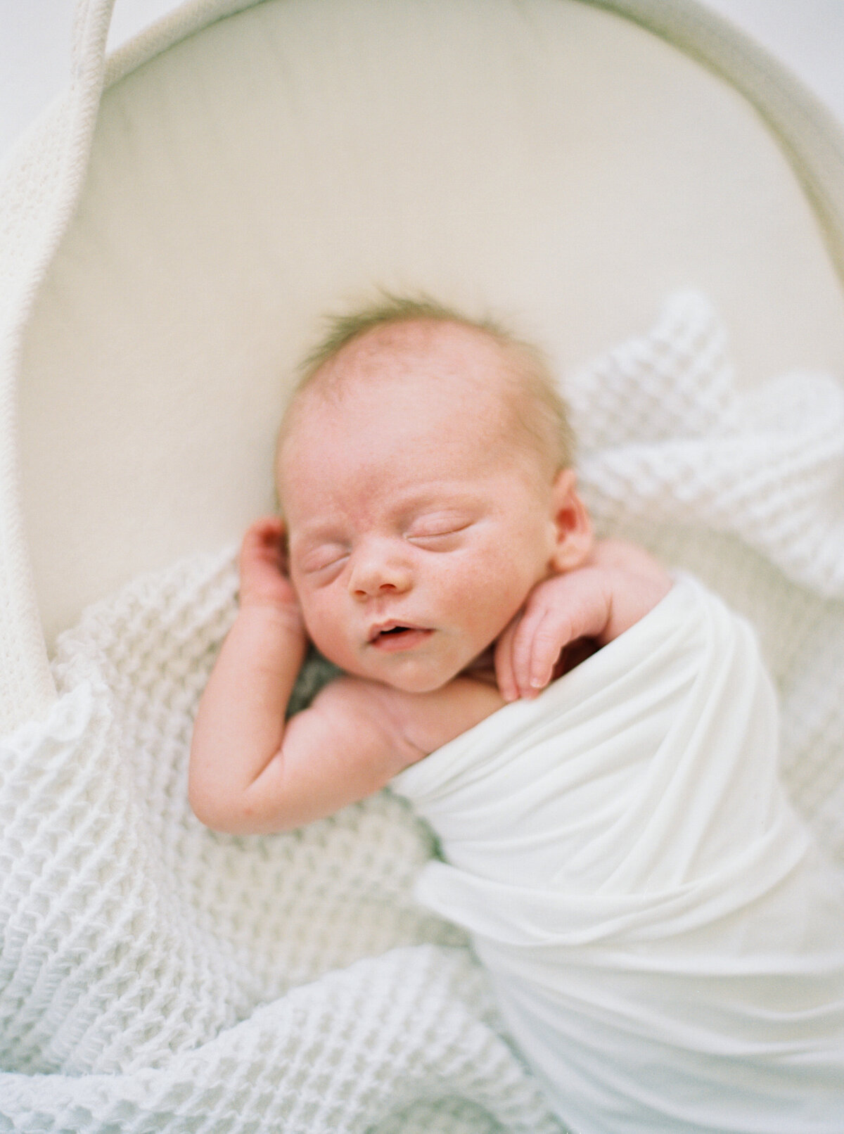 newborn baby boy in all white taken by photographer milwaukee wi talia laird photography