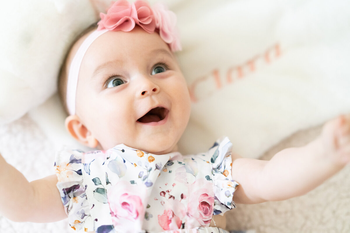 Newborn baby smiles at camera.