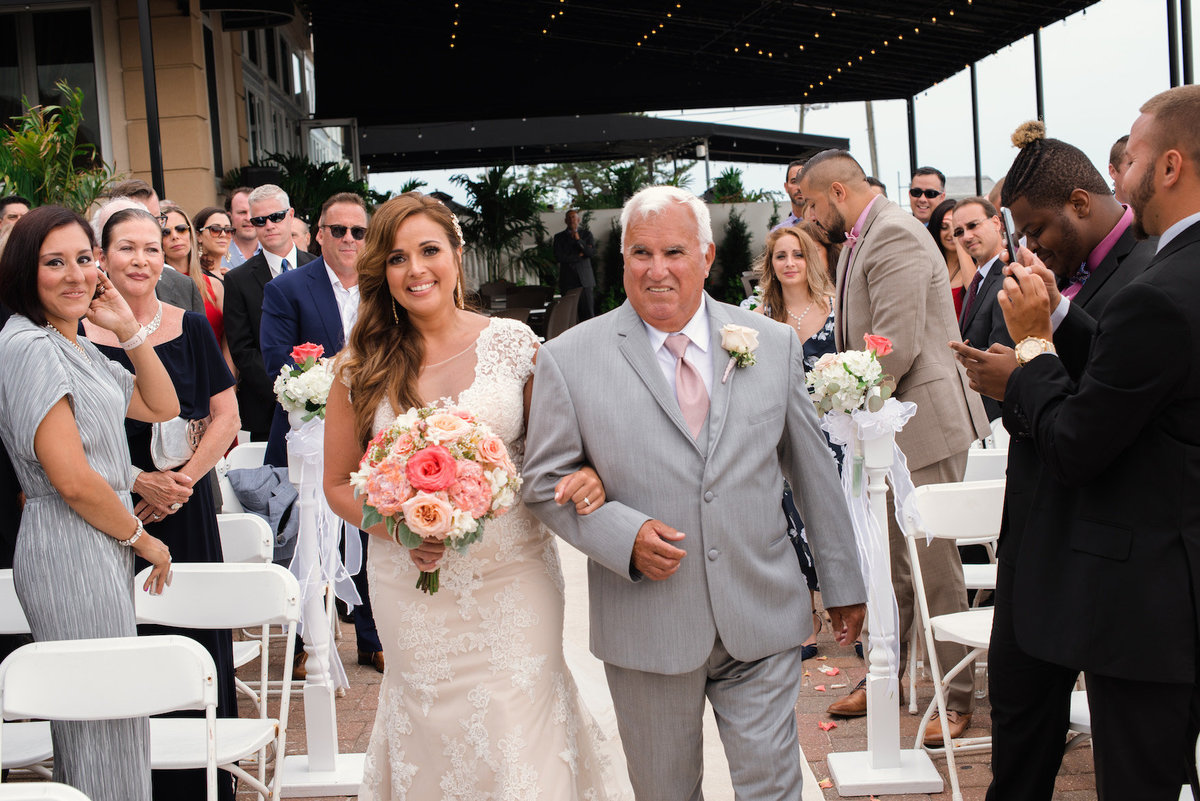 photo of dad walking bride down the aisle during wedding ceremony at Lombardi's on the Bay