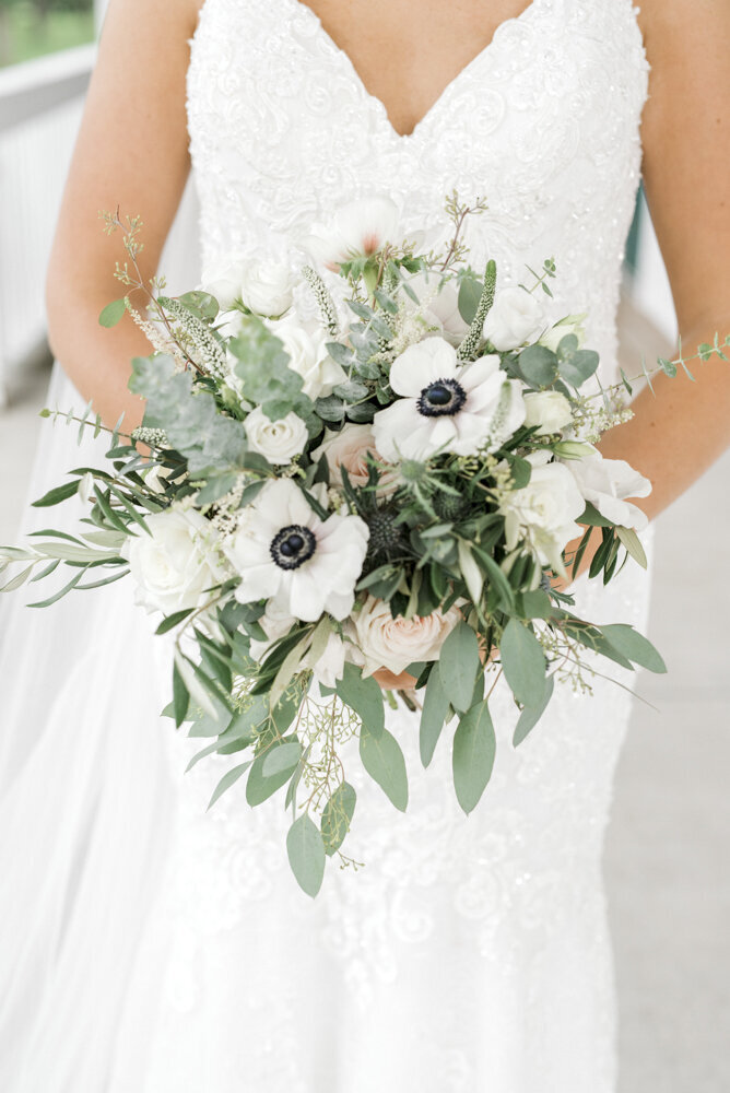 close shot of bride holding white wedding bouquet