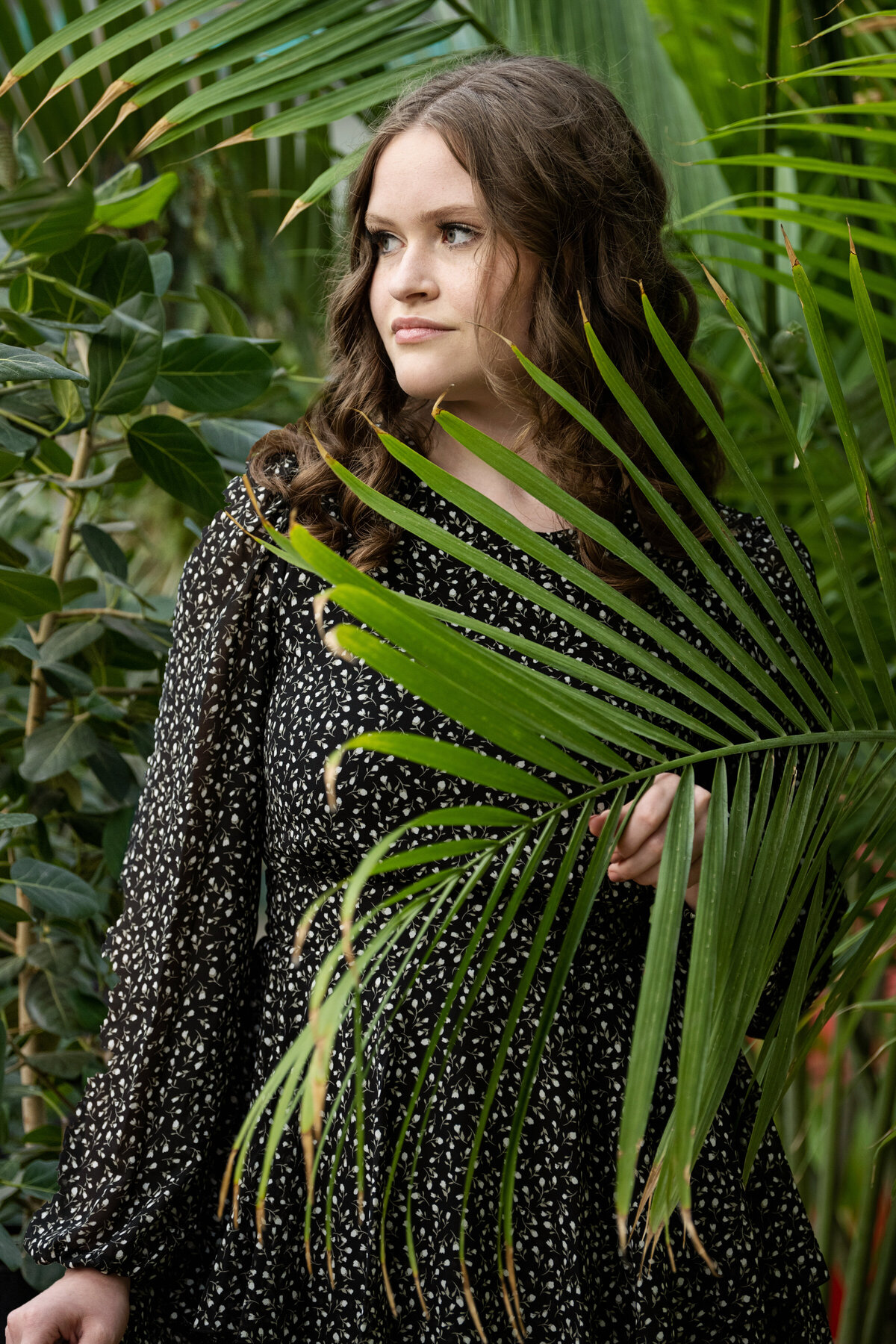 girl in polka dot with long ferns for senior picture