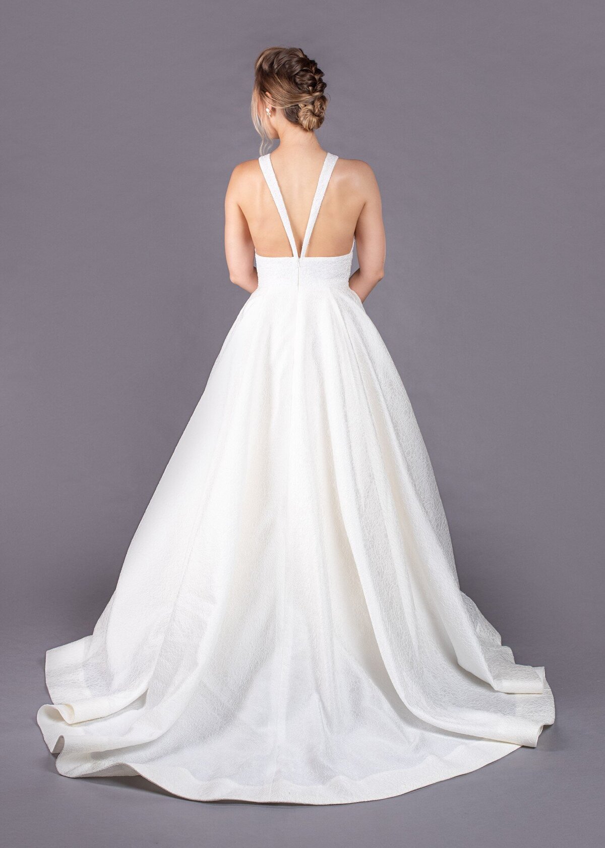 The back view of the Joan wedding dress style shows the full ballgown skirt is paired with a sexy v-back bodice.