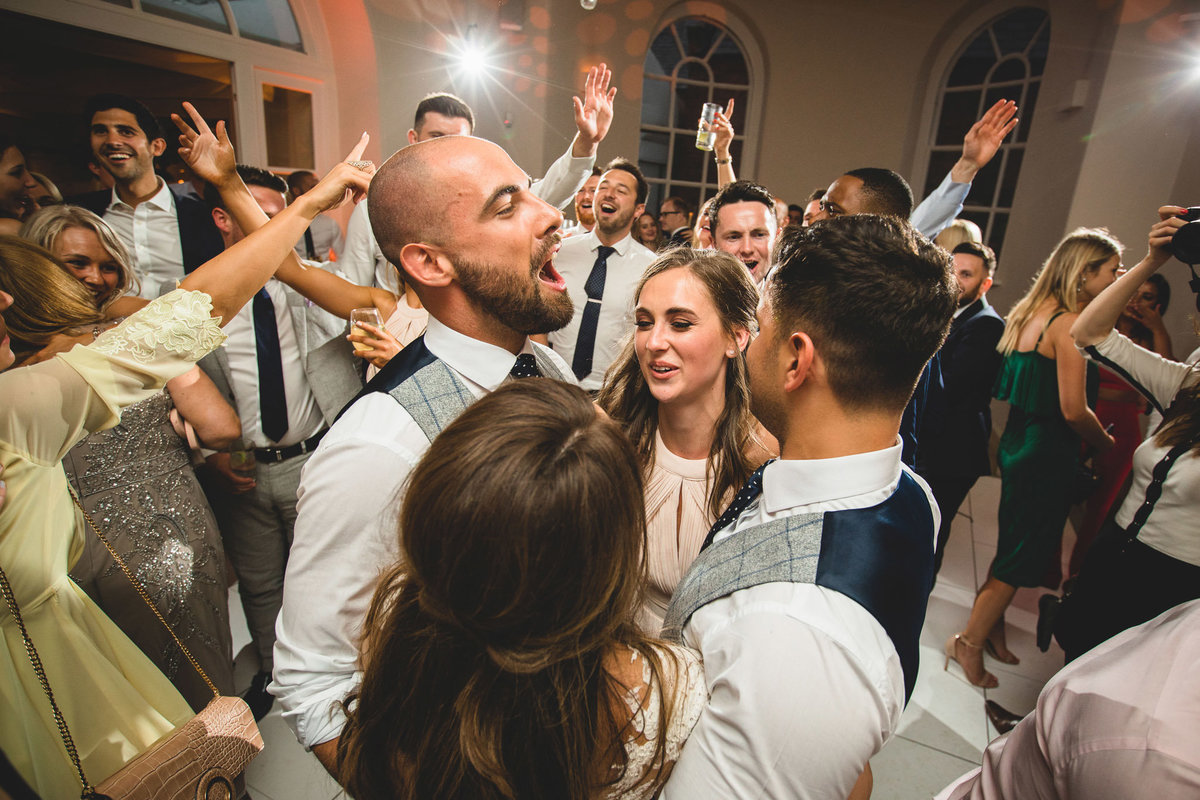 wedding guests on the dancefloor with their arms in the air at Iscoyd Park