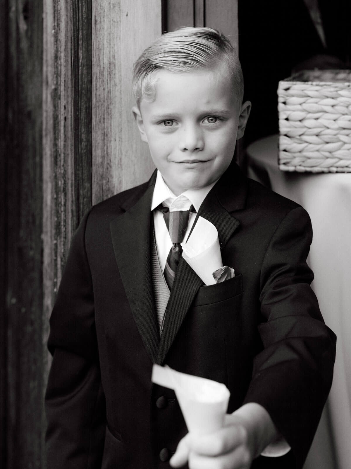 A cute little boy is wearing a coat and tie for the wedding at The Lion Rock Farm, CT. Image by Jenny Fu Studio