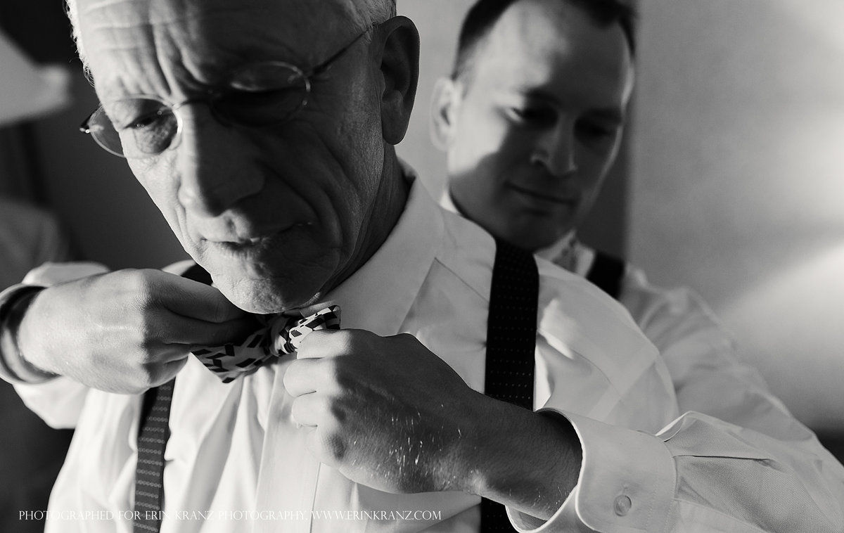 charlotte wedding photographer jamie lucido captures documentary of the men getting ready- the groom adjusts his father's tie from behind