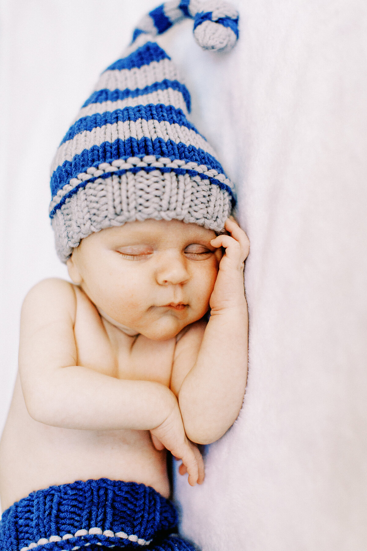 baby boy with blue and gray hat sleeps