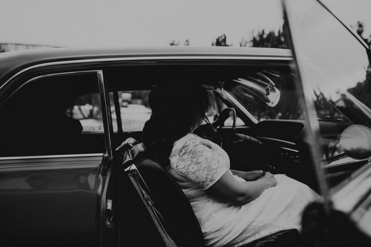bride and groom sitting in a1963 Cadillac