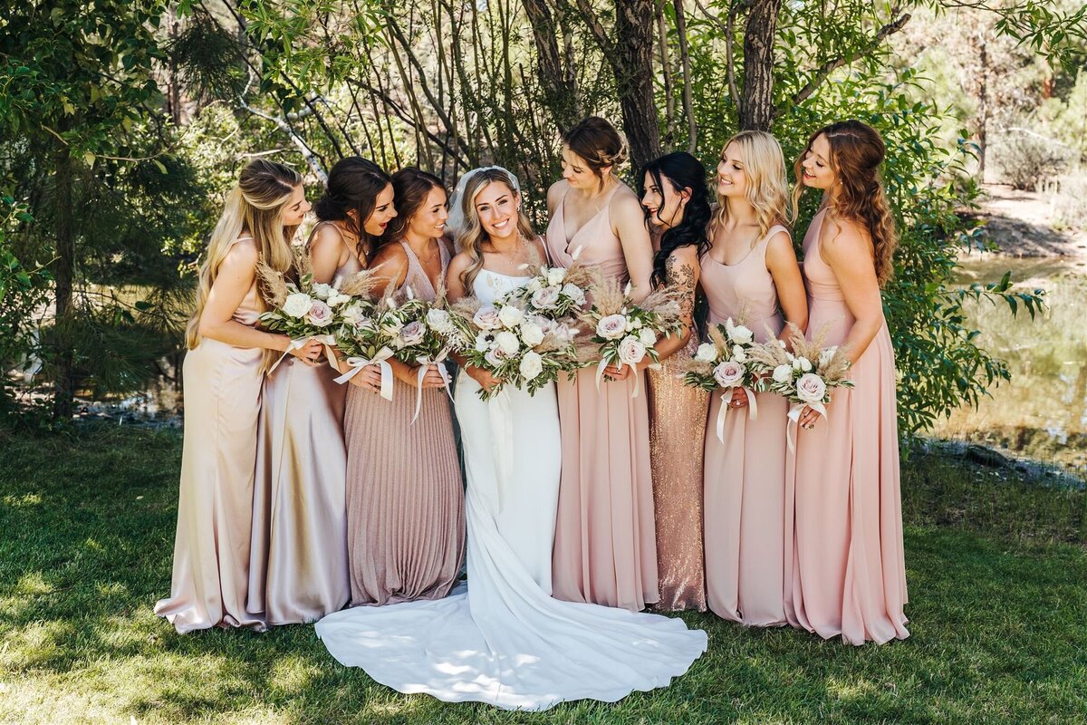 Boho bridal party with pale neutral bridesmaid dressses and bouquets with mauve roses and pampas grass at Rock Springs Ranch