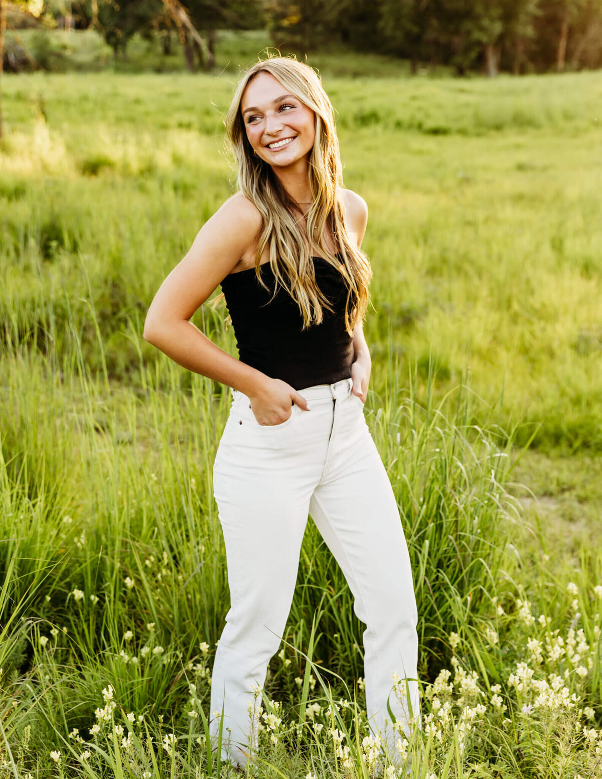 high school girl walking with hands in pocket in a beautiful field by Green Bay Senior Photographer Ashley Kalbus