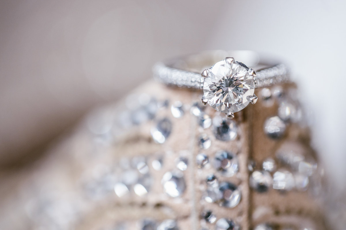 engagement ring sitting on brides wedding shoes