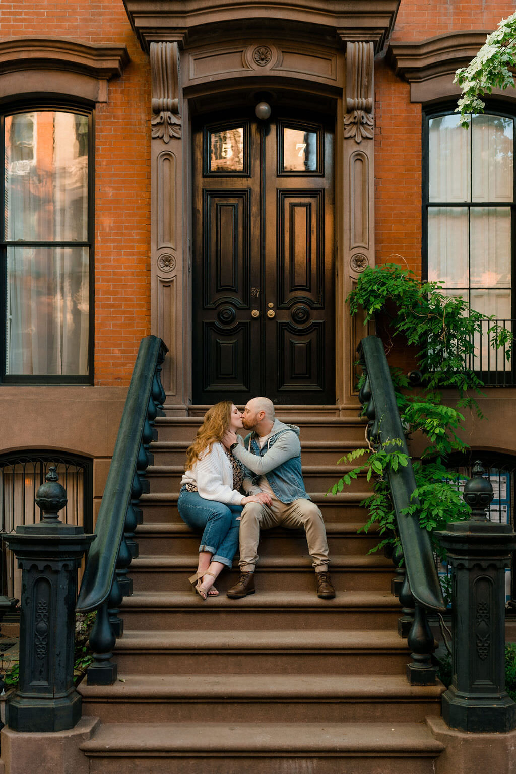 couple sitting on the steps of a building as they kiss