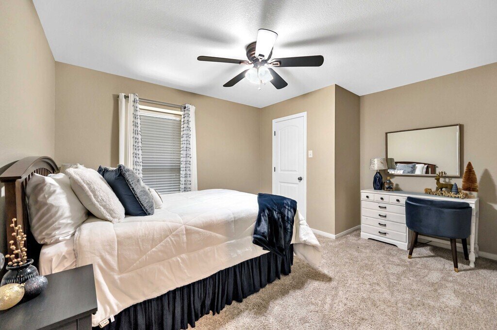 Bedroom with comfortable bedding in this four-bedroom, four-bathroom vacation rental home and guest house with free WiFi, fully equipped kitchen, firepit and room for 10 in Waco, TX.