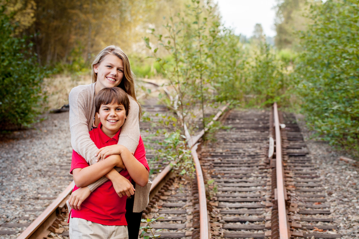 Sibling posing for portraits on dead tracks in Bellevue, WA