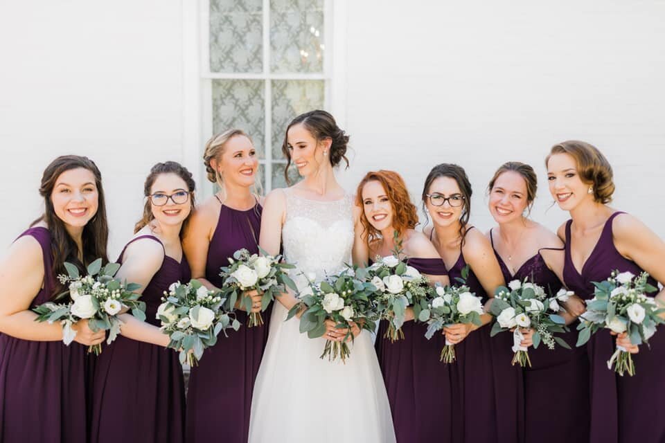 Bride and Bridesmaid holding greenery and white bouquets