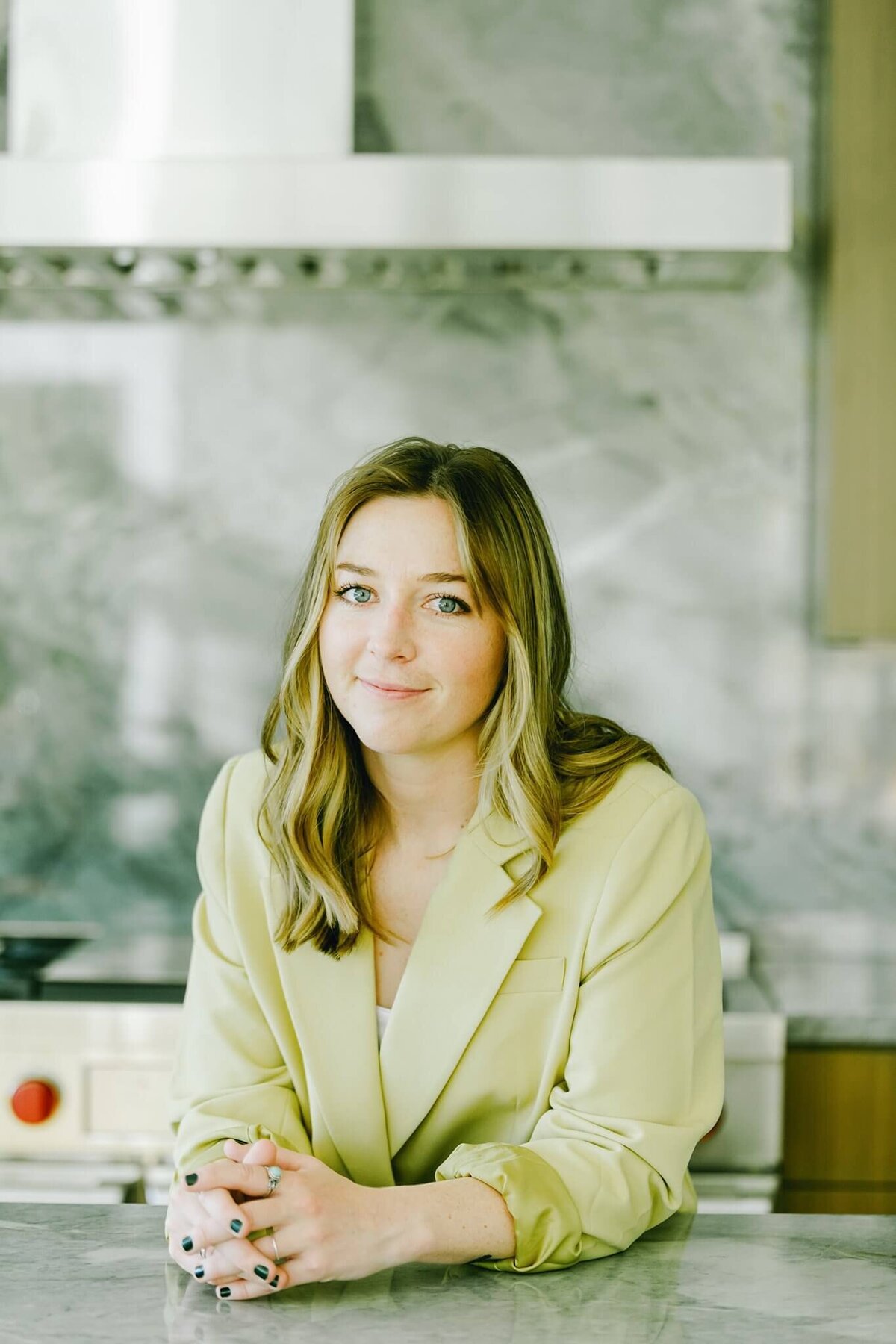 interior designer headshot in a built new kitchen at the counter