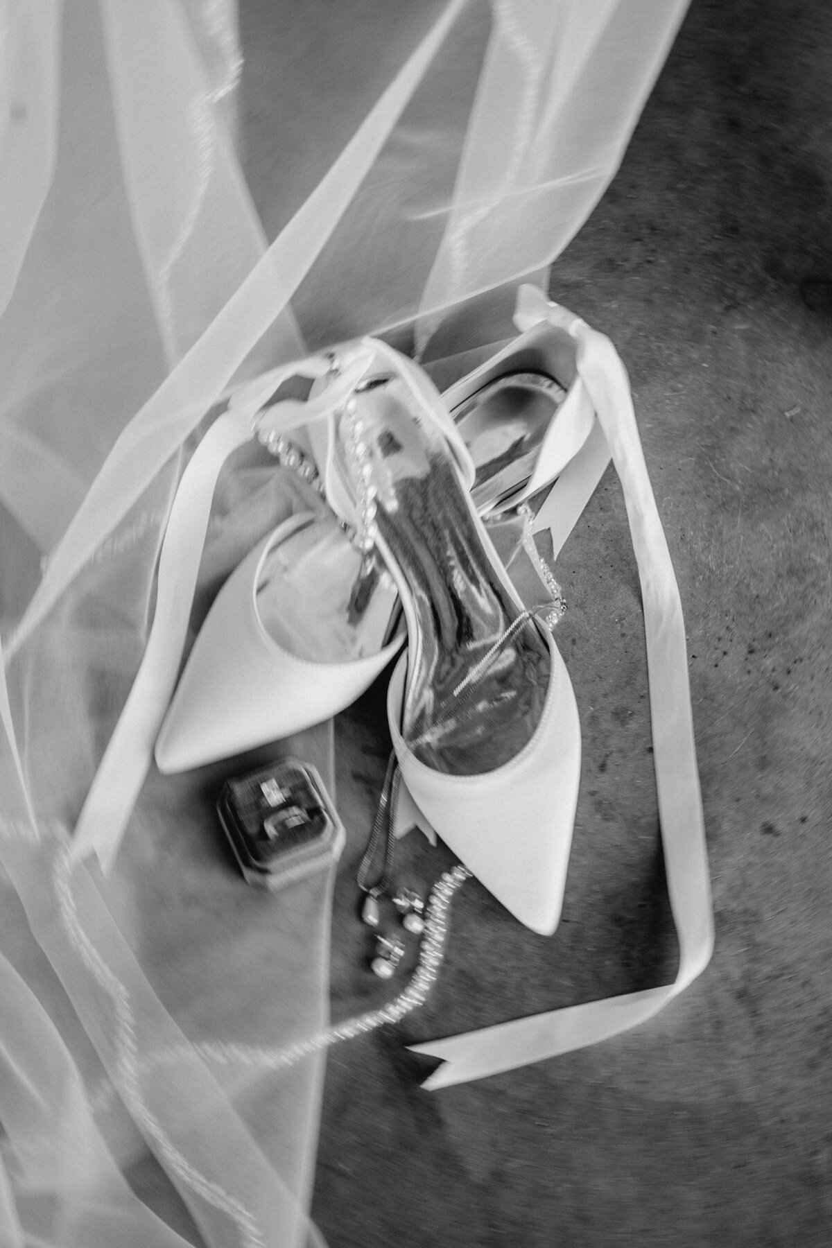 Elegant wedding shoes and details laid on top of a wedding veil in Elbert, Colorado.