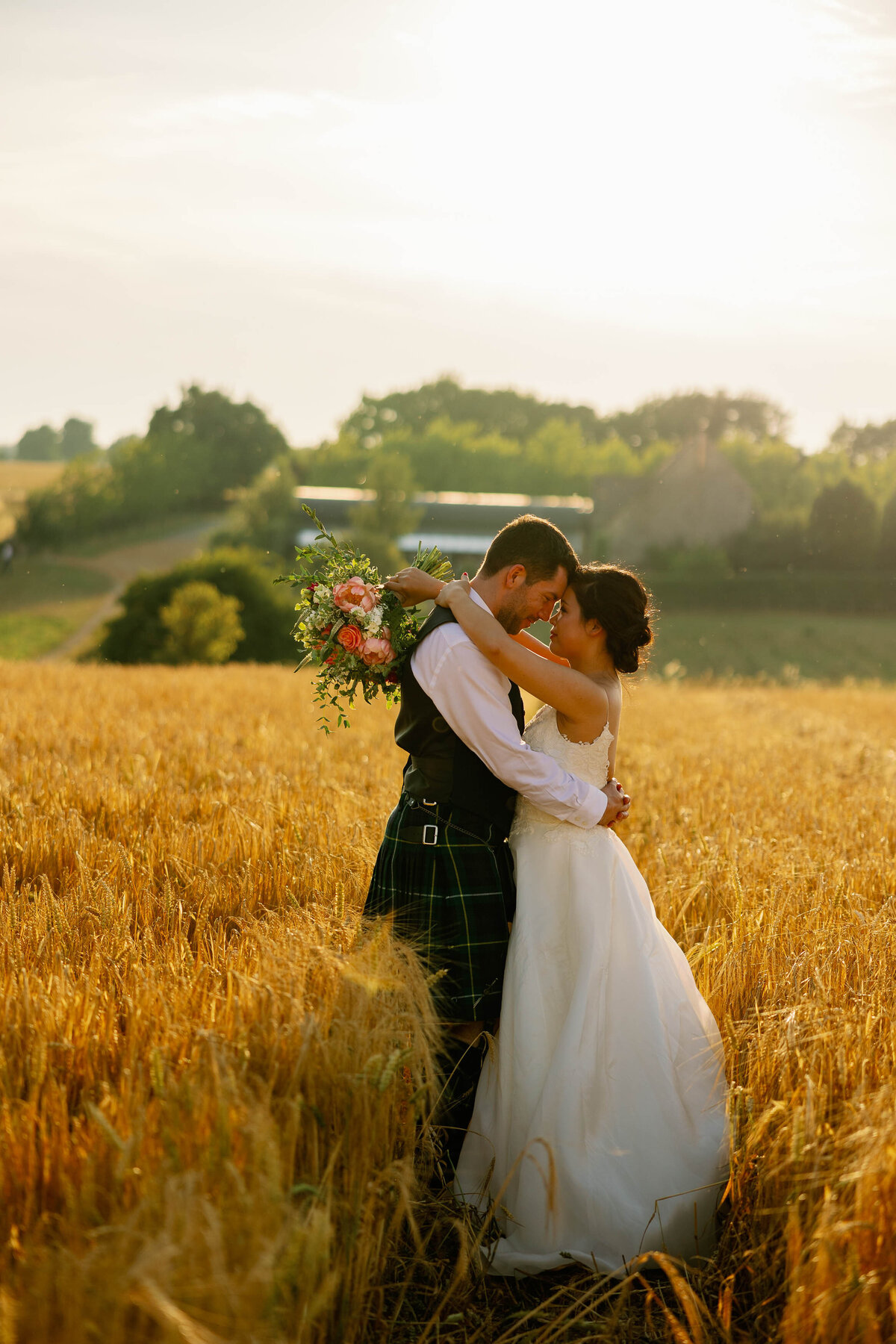 Couple with their arms around each other in the summer sun at Stone Barn