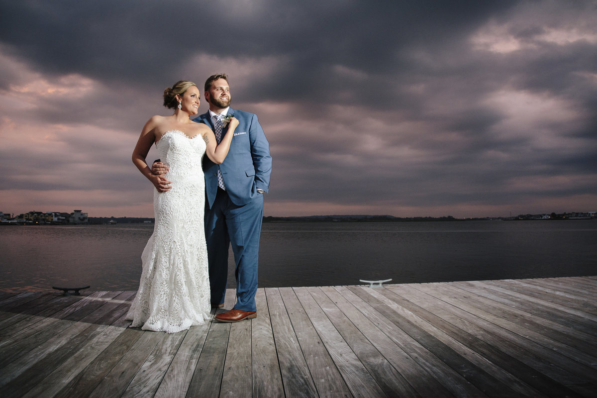 bride and groom at sunset on dock at channel club wedding