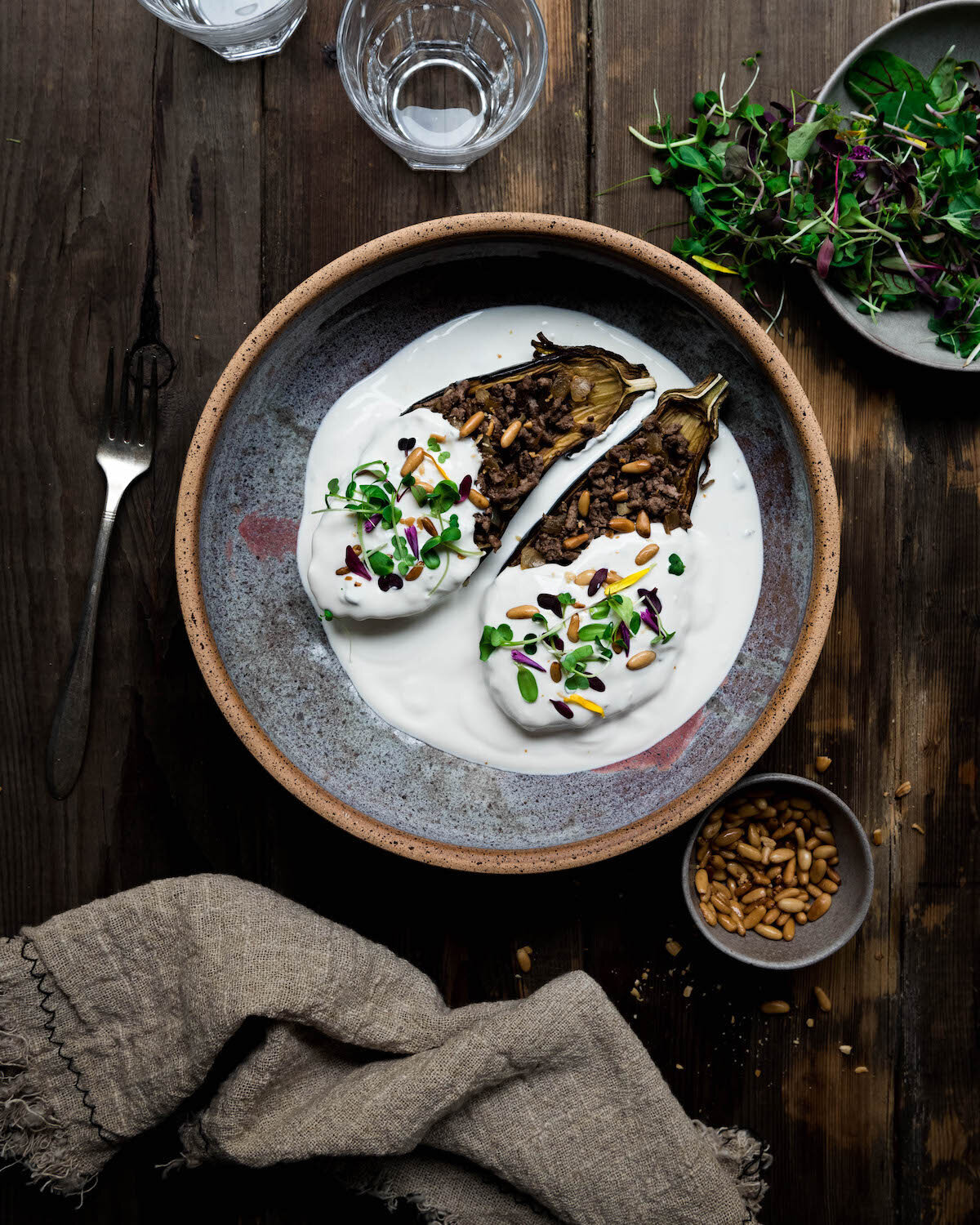Omayah Atassi Dubai Food Photographer - Overhead shot of eggpalnt boats on a purple plate and wooden backdrop