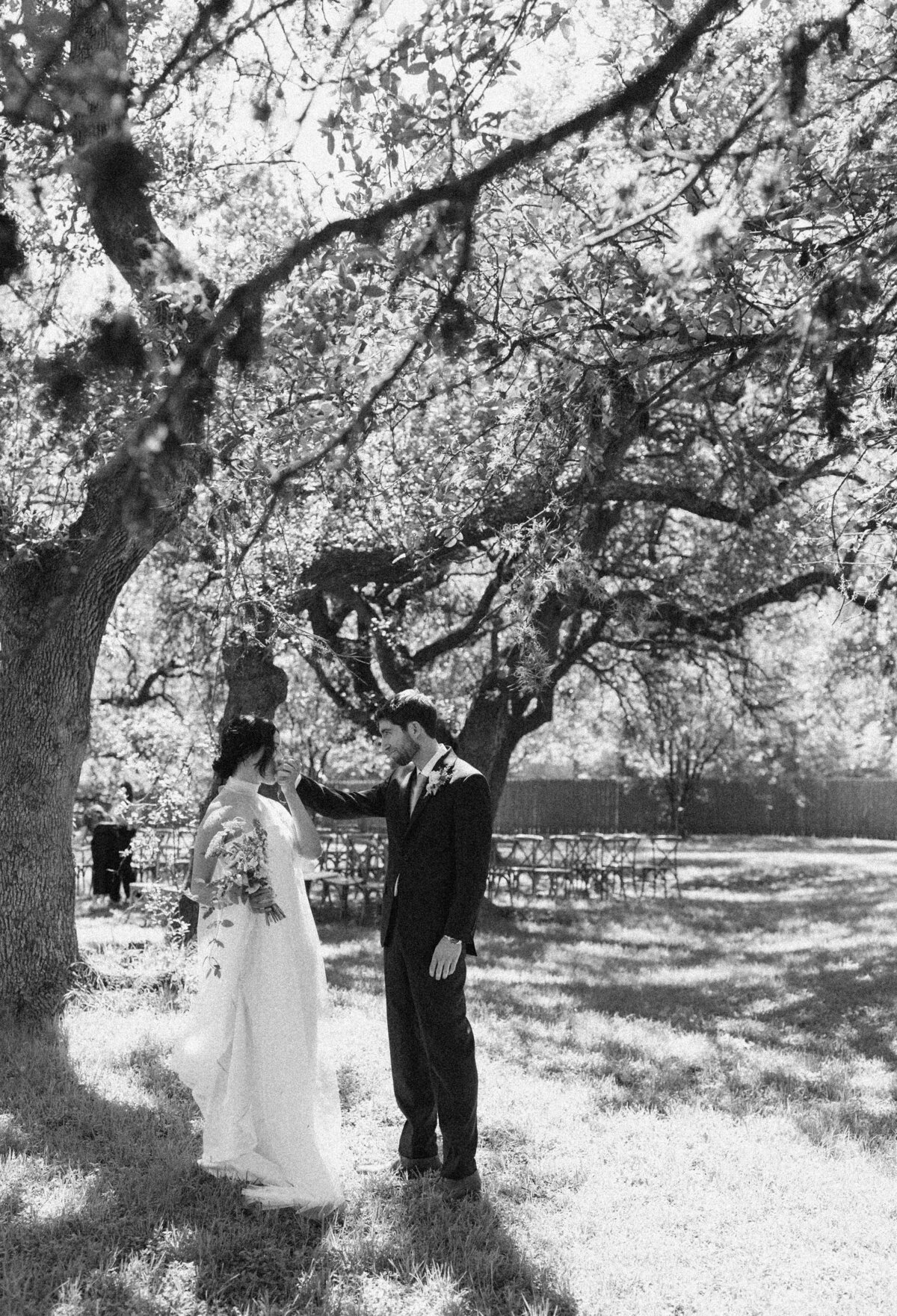Bride and groom standing beneath a tree at Mattie's  Austin Wedding
