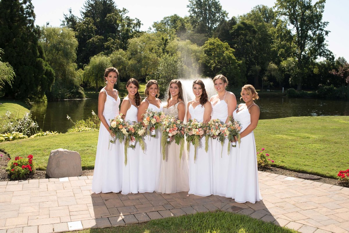 Bride and bridesmaids holding bouquets outside at Flowerfield