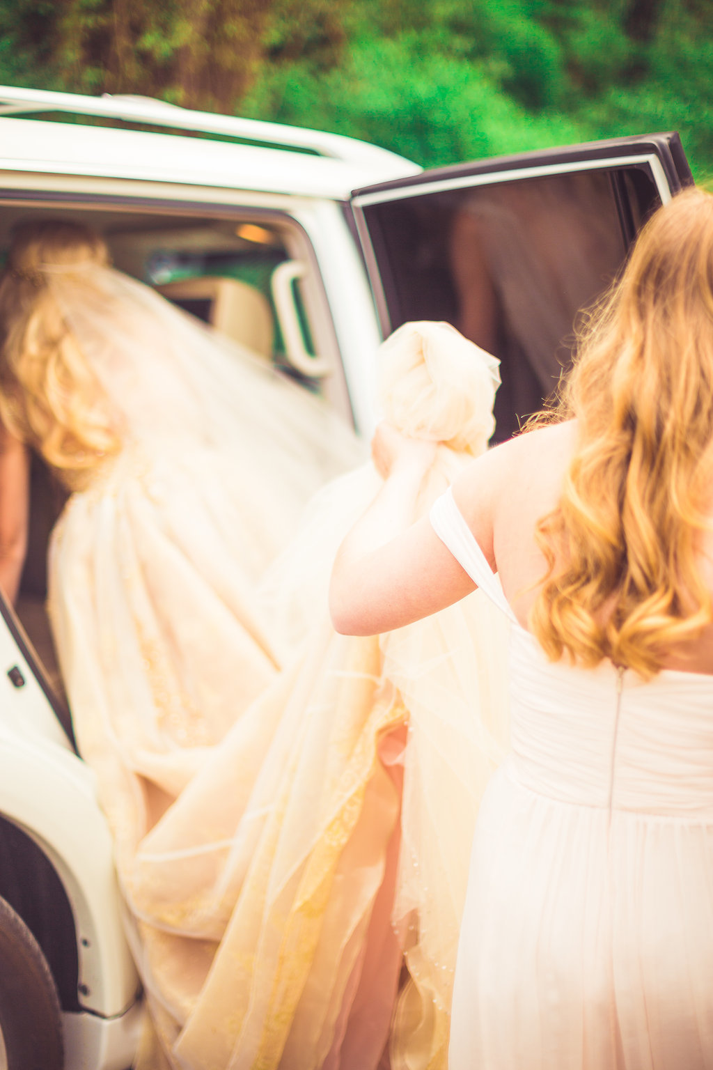 Wedding Photograph Of Maid of Honor Assisting the Bride  Getting on the Bridal Car Los Angeles