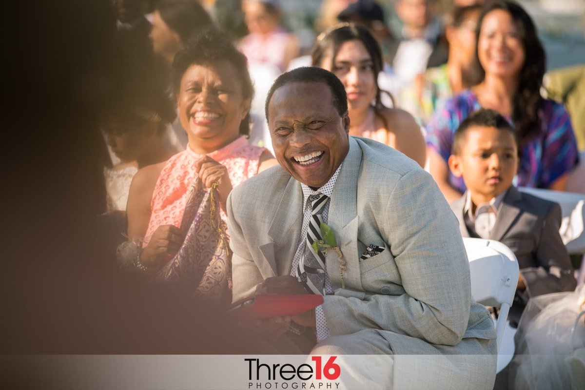 Parents of the Groom break up in laughter during the ceremony