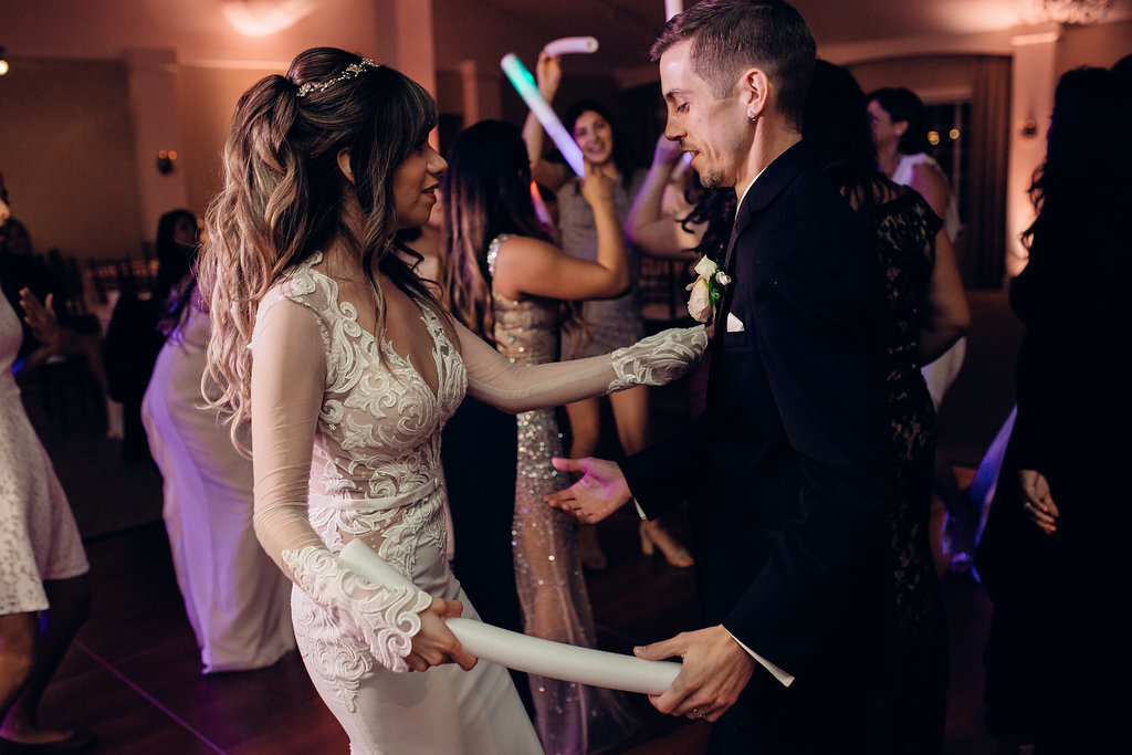 Wedding Photograph Of Bride And Groom Holding a Light Stick While Dancing Los Angeles