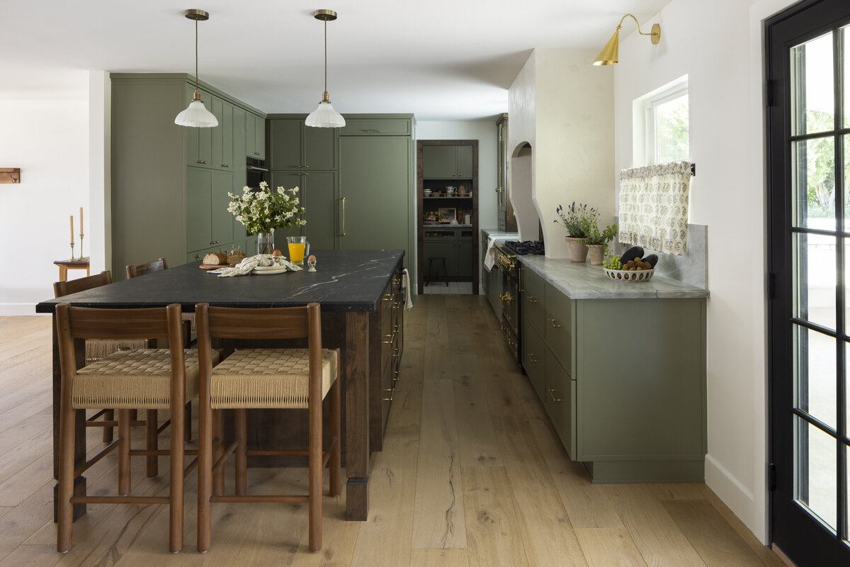 Full kitchen remodel with green skinny shaker cabinets iwth brass hardware. white oak wood floors with a walnut stained island.  Brass wall sconces over cafe curtains