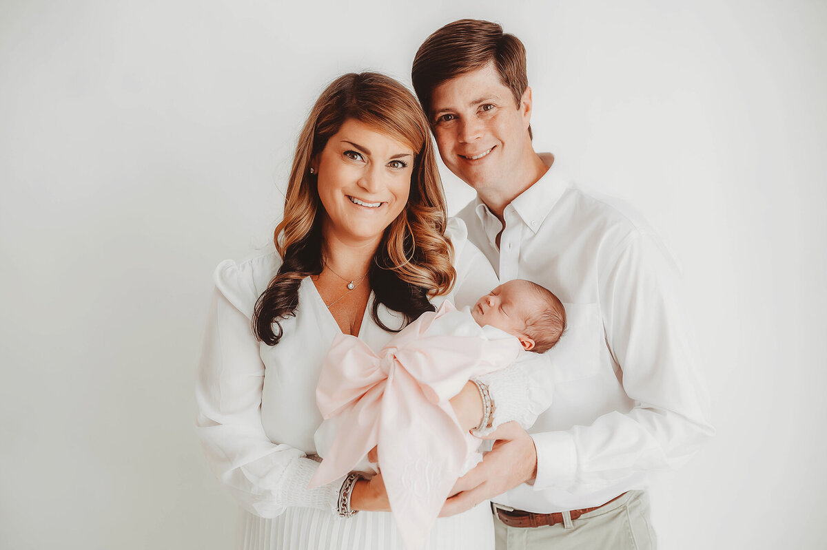 Parents hold their infant daughter during Newborn Photoshoot in Asheville.