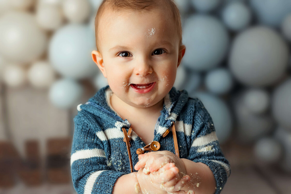 one year old baby clapping at a cake smash session