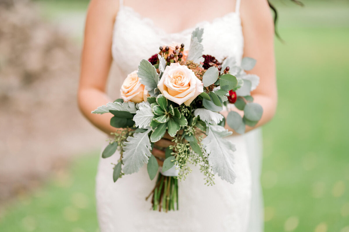 Soft pink and lush greenery bouquet being held by a bride